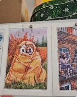 Cozy postcard of two dogs wrapped together in an orange blanket on autumn grass