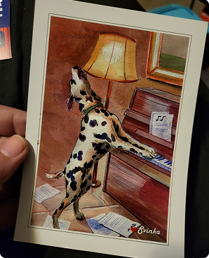 Watercolor postcard of a Dalmatian playing an upright piano by a glowing lamp
