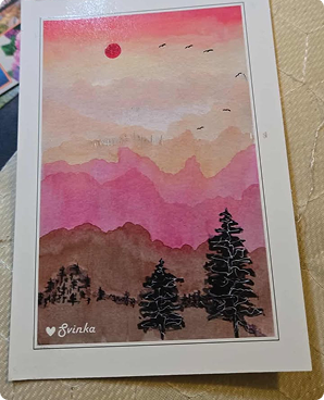Postcard of layered pink mountains at sunset with pine silhouettes and birds