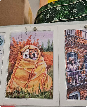 Cozy postcard of two dogs wrapped together in an orange blanket on autumn grass
